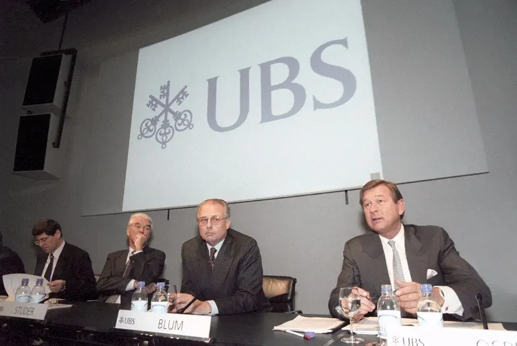 Pressekonferenz zur Bekanntgabe der UBS-Fusion, 8. Dezember 1997. Auf der rechten Seite sitzen Georges Blum und Marcel Ospel vom Schweizerischen Bankverein aus Basel, auf der linken Seite Mathis Cabiallavetta und Robert Studer von der Schweizerischen Bankgesellschaft aus Zürich