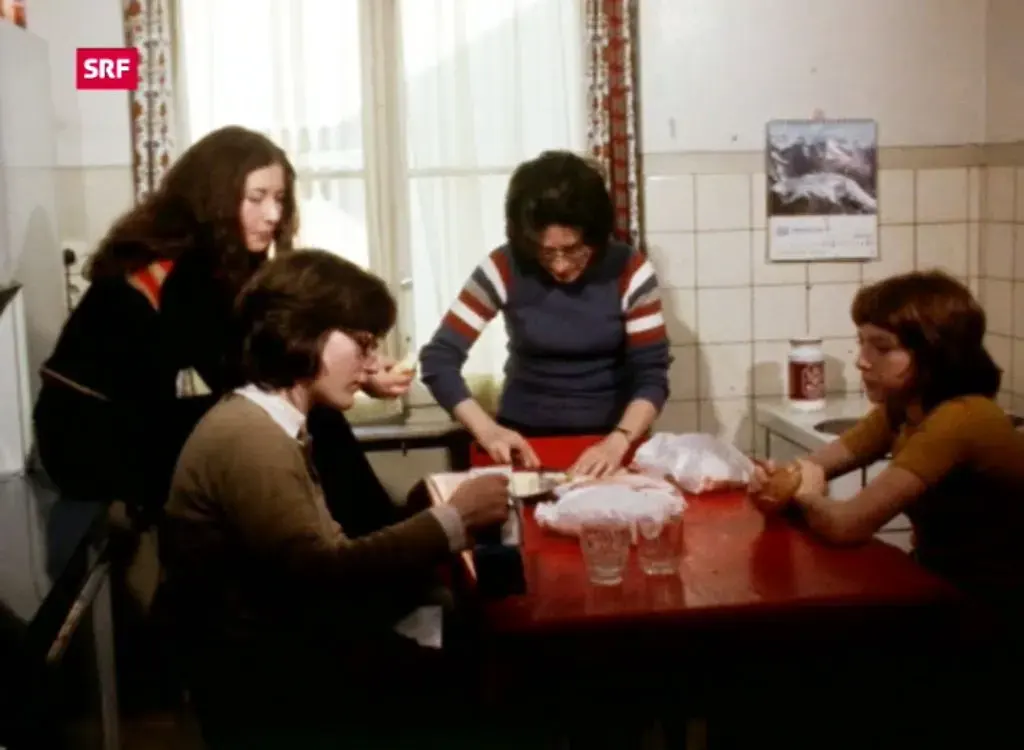 Ein SRF-Beitrag von 1973 zeigt eine Gruppe von Menschen um einen Tisch, die Sandwiches essen