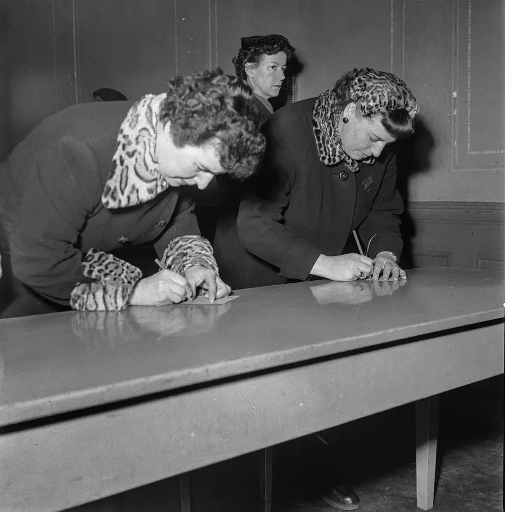 Archivbild: zwei Frauen schreiben auf einen Abstimmungszettel